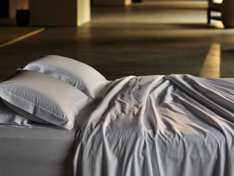 Set di lenzuola in percalle bianco su un letto ordinato